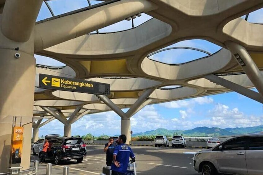 A modern architectural structure with a departure sign for 'Kebarangkatan.' 3