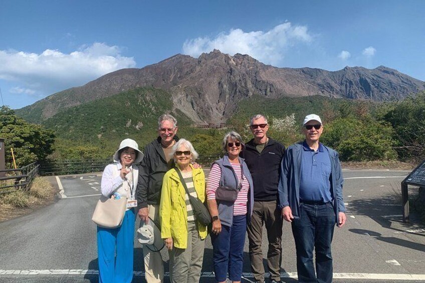 A group of people standing on a road with a mountainous landscape in the background. 3