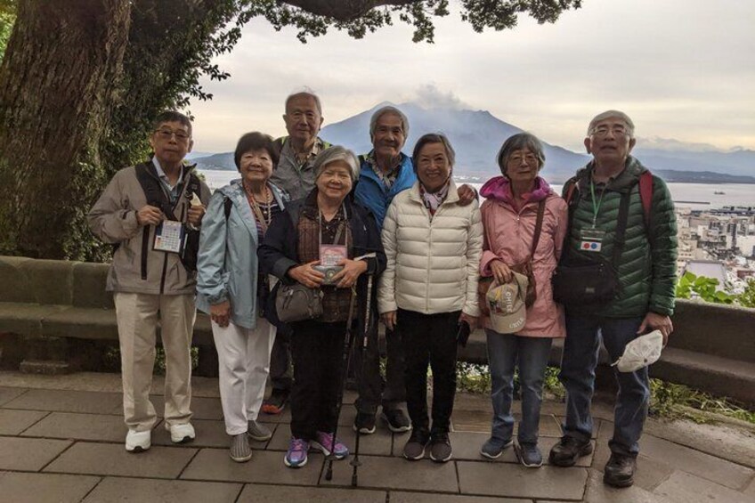 A group of people standing on a stone pathway with a mountainous landscape in the background. 4