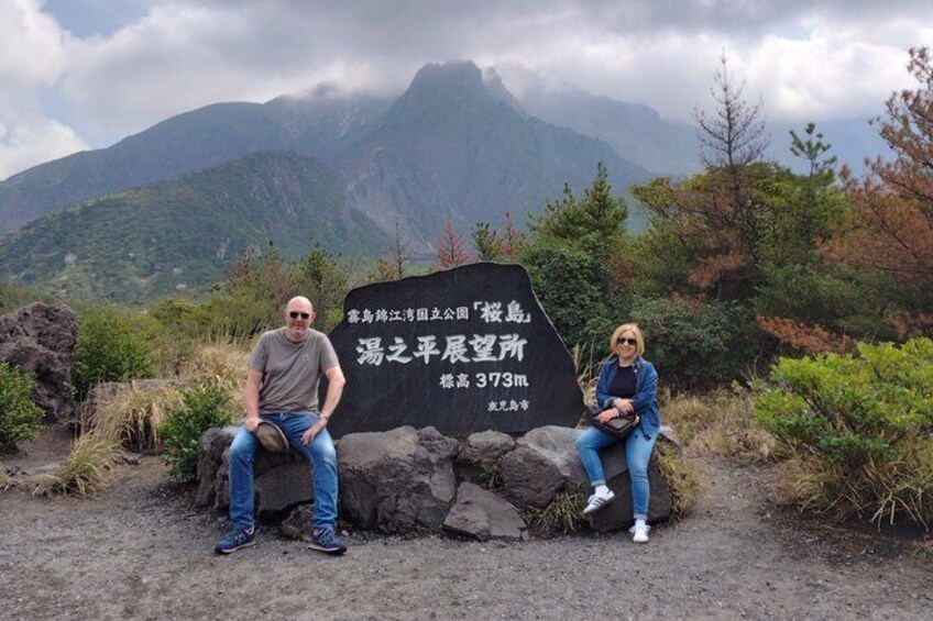 Two people sitting on rocks with a mountain and a sign in the background. 5