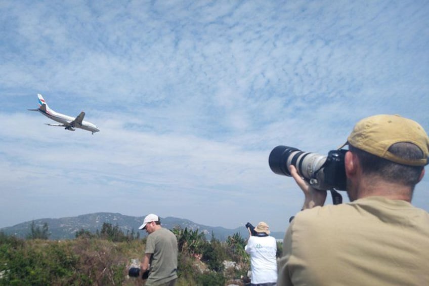 Une personne prend une photo d’un avion qui vole dans le ciel. 2