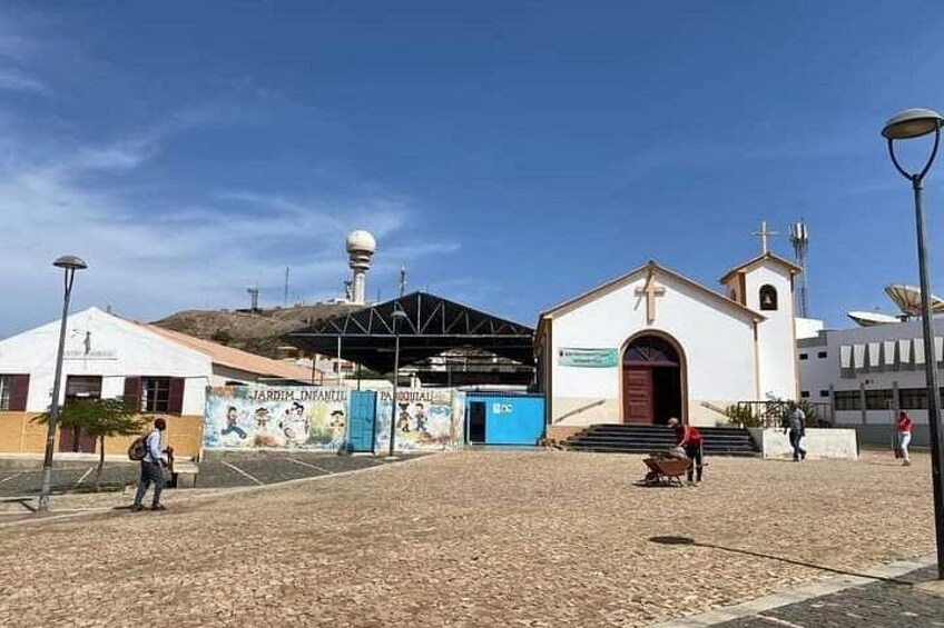 A church with a bell tower, a playground, and a building with a satellite dish. 3