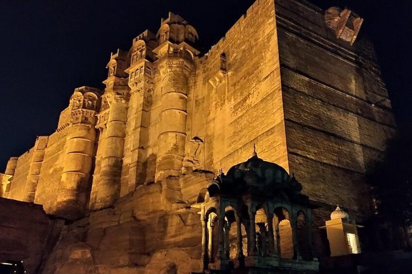 A large, illuminated historical structure with multiple towers and arches. 1