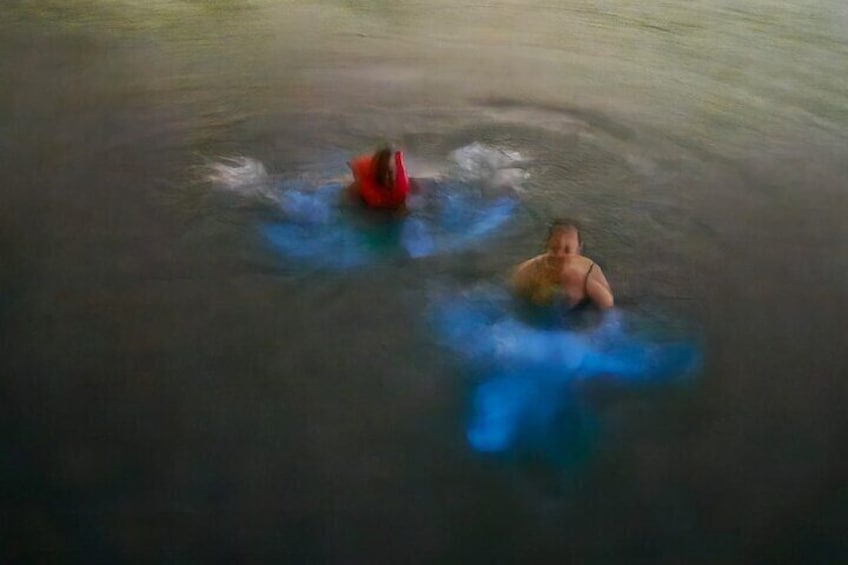 Two people swimming in a body of water. 1