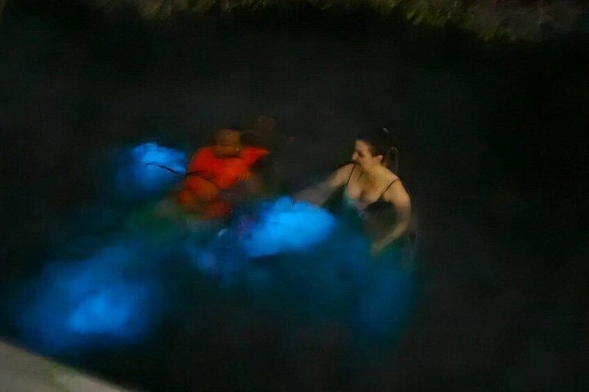 A person in a red life jacket and another in a blue swimsuit in a body of water. 5