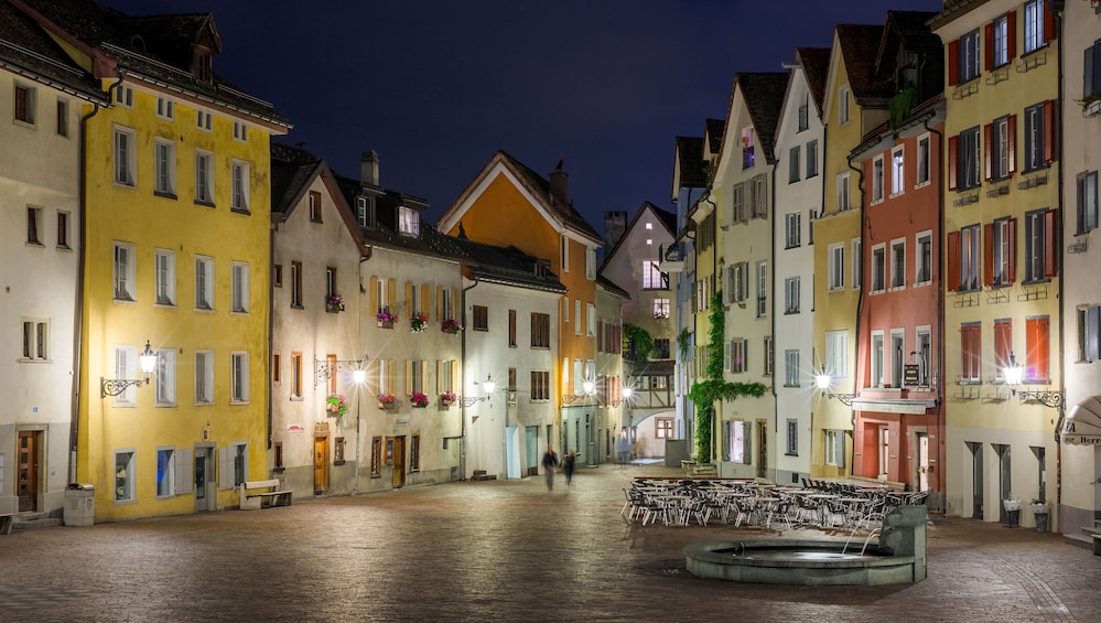 A cobblestone square with colorful buildings and a fountain. 4