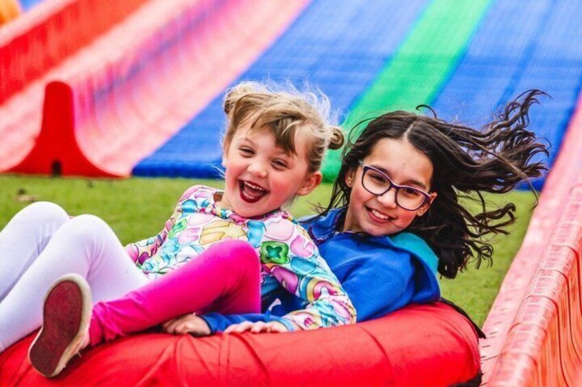 Two children sliding down a colorful slide. 3