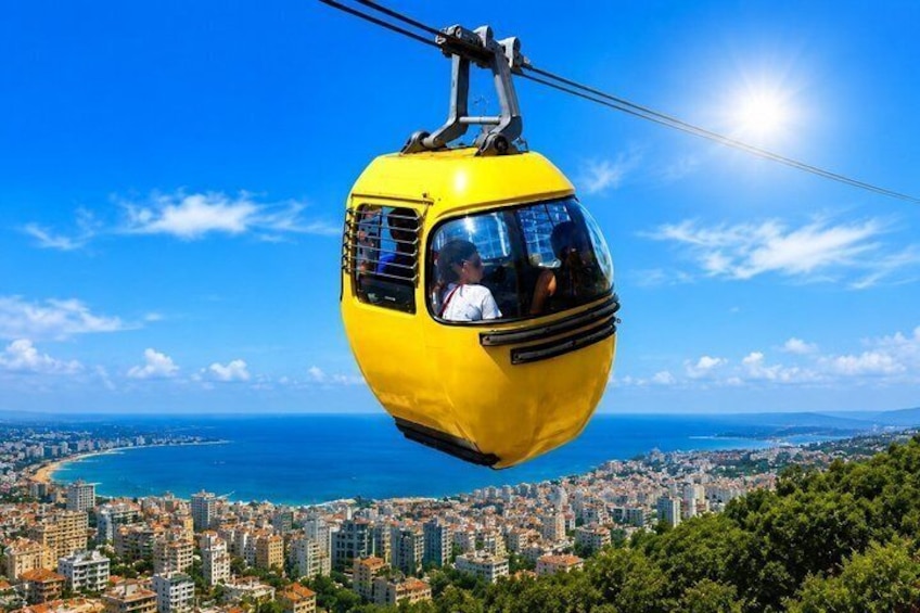 Un teleférico amarillo sobre una ciudad costera bajo un cielo azul despejado. 4
