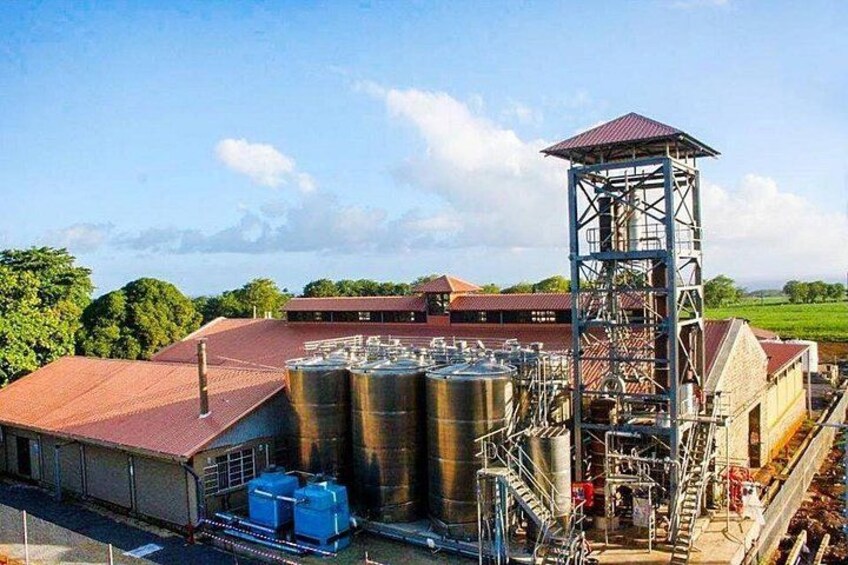 Un vaste complexe industriel comprenant de nombreux réservoirs de stockage, une haute structure métallique et un bâtiment au toit rouge. 4