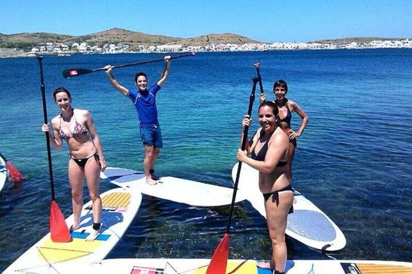 People on paddleboards in a body of water with a distant shoreline. 3