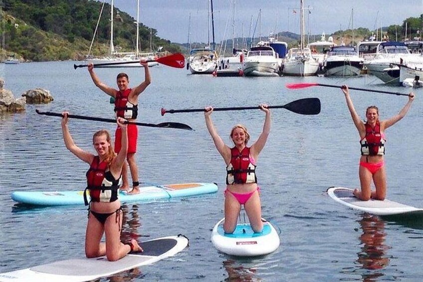 People on paddleboards in a marina with boats in the background. 5