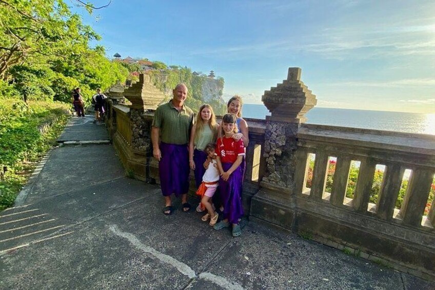 A family on a stone bridge with a view of the ocean. 2