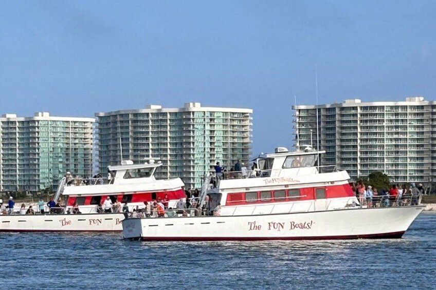 To både med navnet 'The FUN Boats' på vandet med høje bygninger i baggrunden. 4