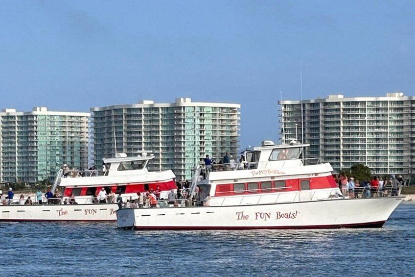 Zwei Boote mit dem Namen 'The FUN Boats' auf dem Wasser, mit einer Stadtlandschaft im Hintergrund. 4