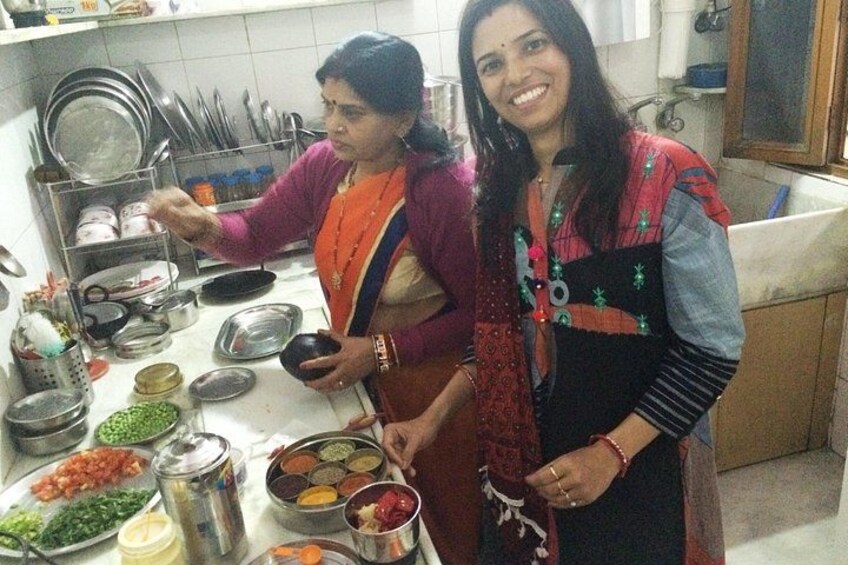 Two people in a kitchen preparing food with various dishes and utensils. 2
