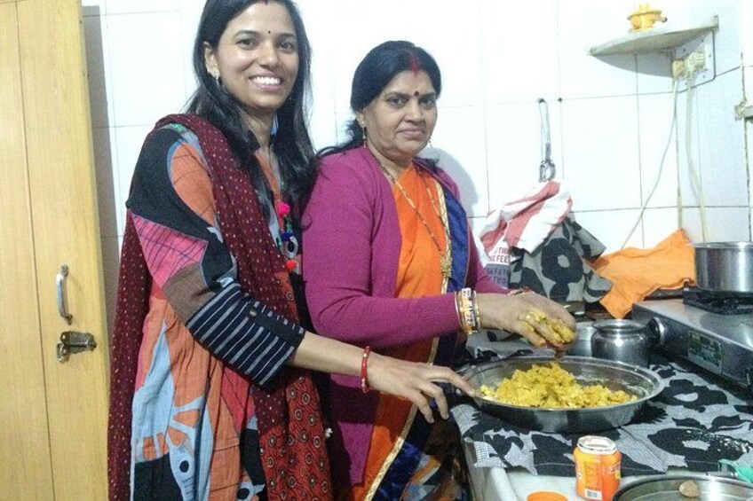 Two people cooking in a kitchen with a stove and cooking utensils. 5