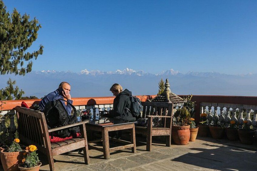 Dos personas sentadas en una mesa con vistas a una cadena montañosa. 3