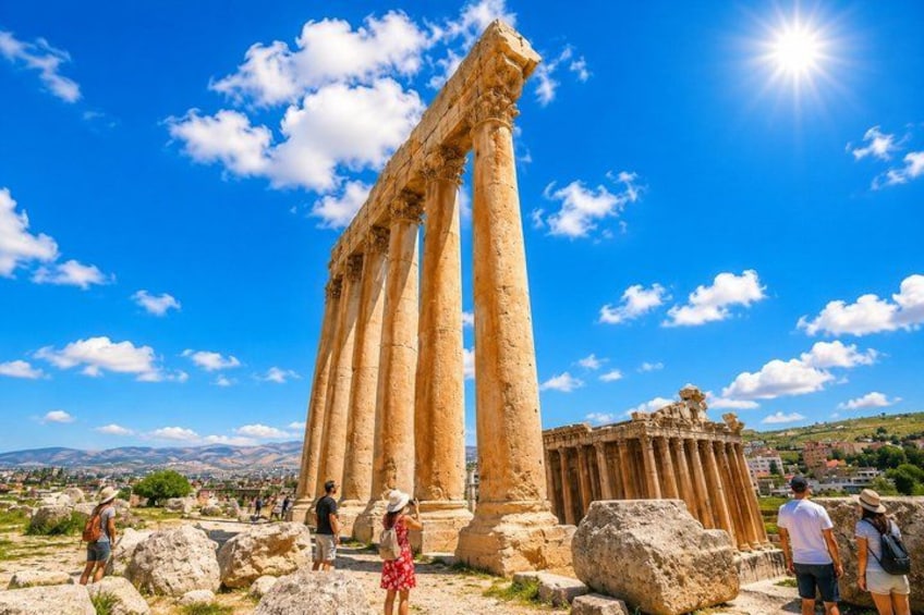 Ancient columns, a clear blue sky, and a distant mountain range. 2