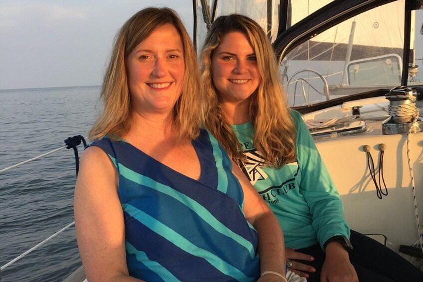 Two people on a boat with a calm sea and a clear sky in the background. 3