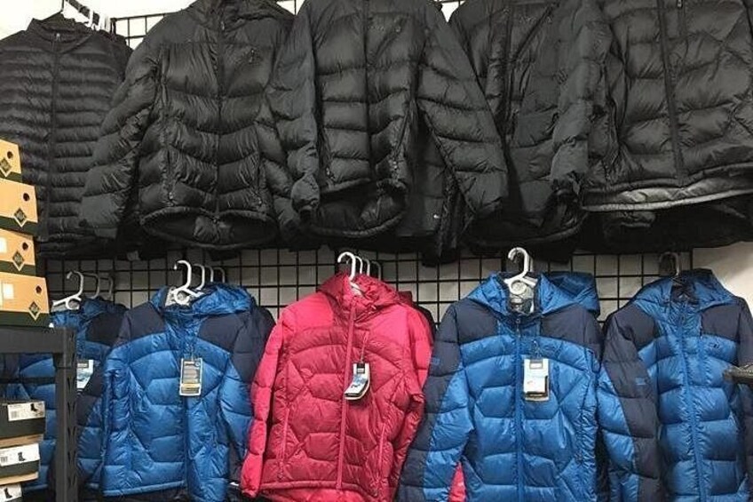 A rack of puffer jackets in black, blue, and red colors. 1