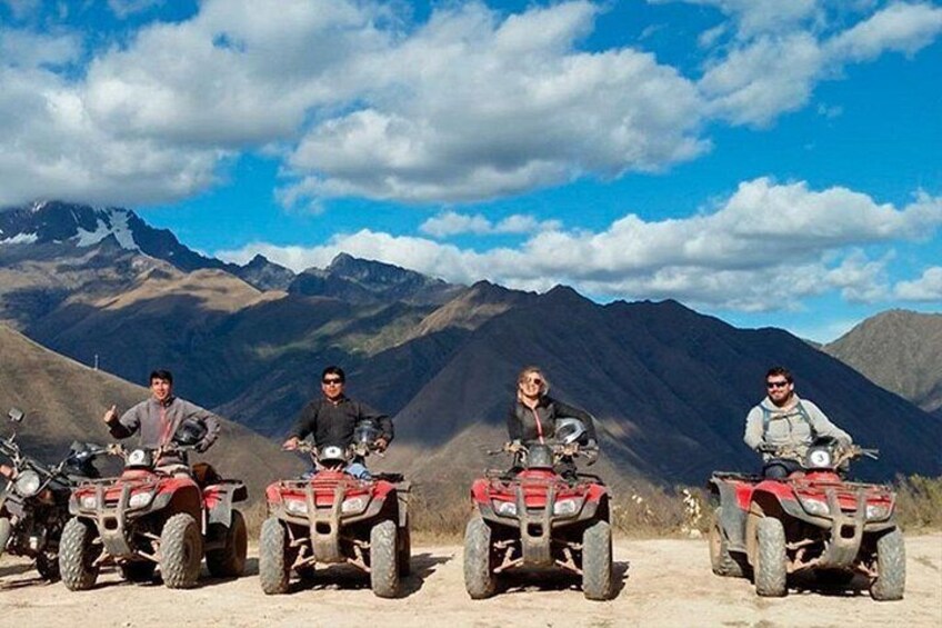 Quattro persone su veicoli fuoristrada rossi in un paesaggio montuoso. 3