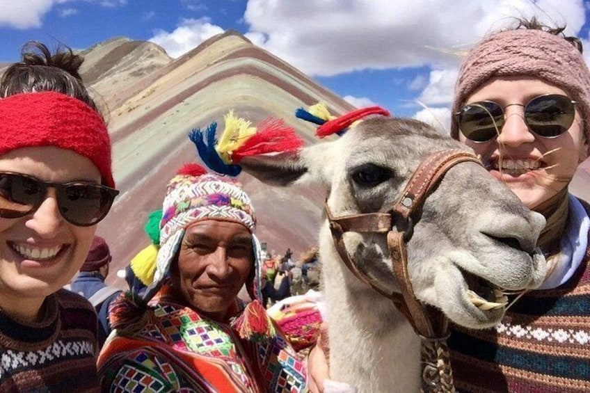 Un lama decorato con colori vivaci, una persona in abiti tradizionali e un paesaggio montuoso. 4