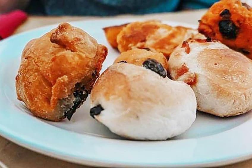 Un plato de pasteles, incluyendo un pastel frito dorado y un pastel blanco y redondo. 2