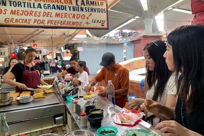 Un puesto de comida con personas preparando y sirviendo alimentos. 3