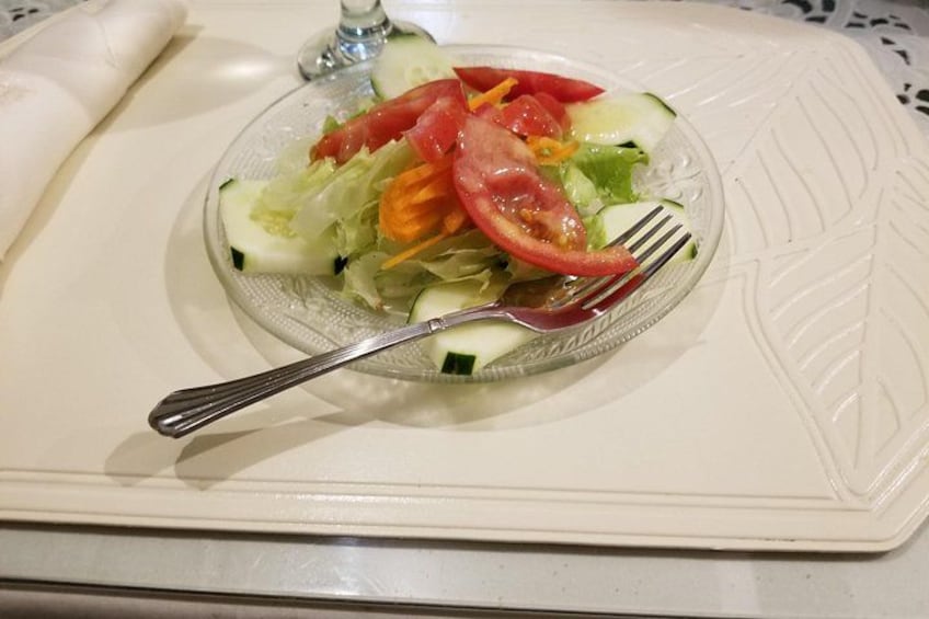 A glass salad bowl with a fork on a white plate. 2