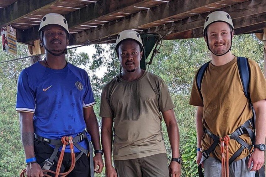 Tres personas con casco y arneses, de pie bajo una estructura de madera. 5
