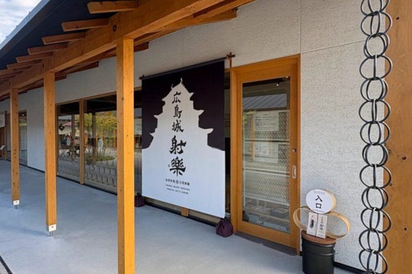 Un edificio con un letrero en japonés, vigas de madera y un basurero. 3