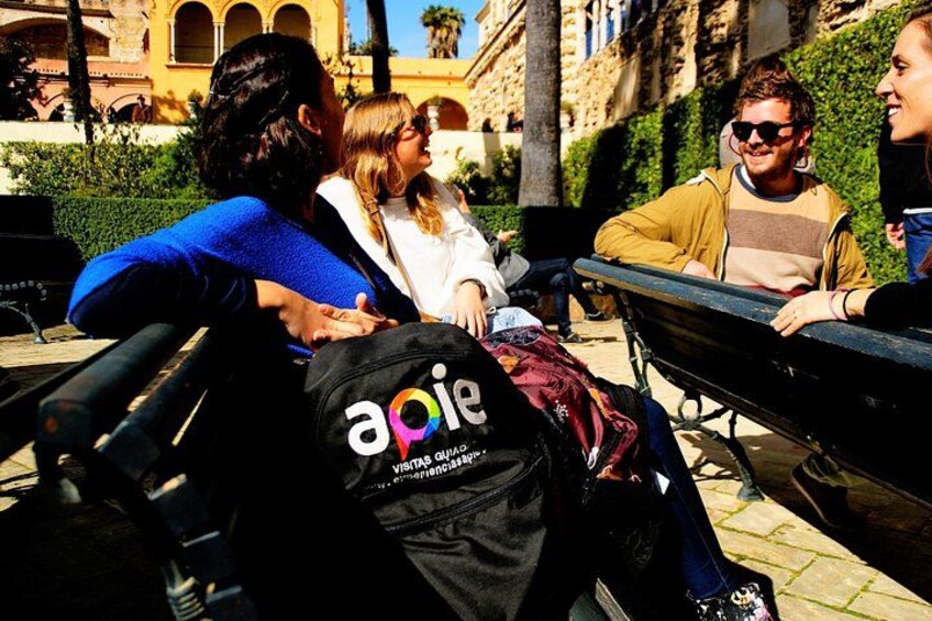 People sitting on a bench in an outdoor setting with a building in the background. 3
