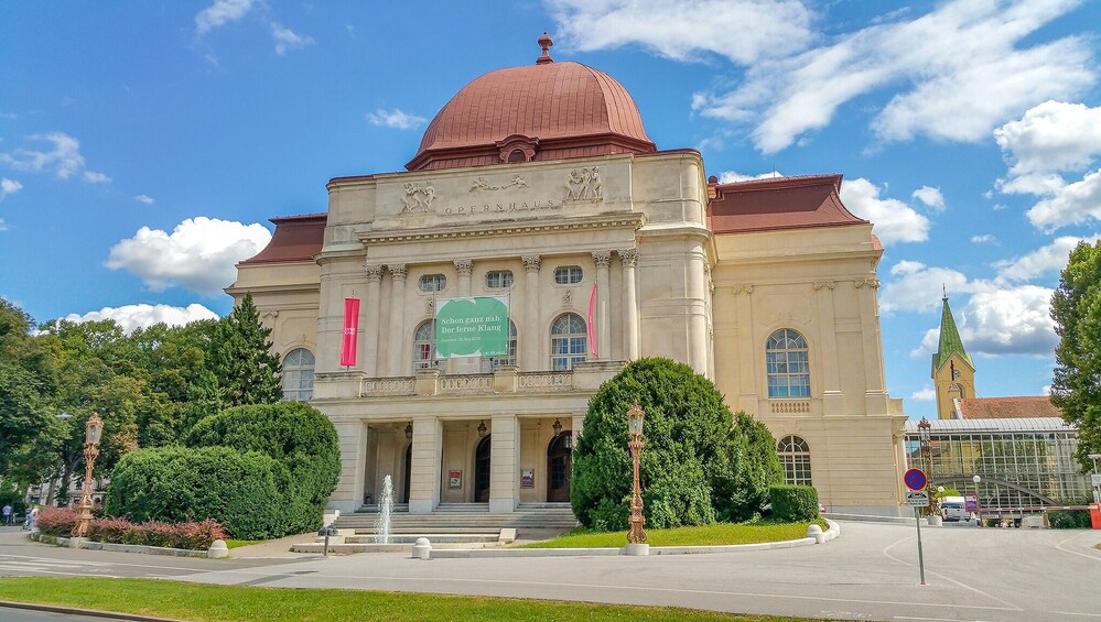 Un bâtiment de style classique, doté d’un dôme rouge, de colonnes et d’une bannière verte. 4