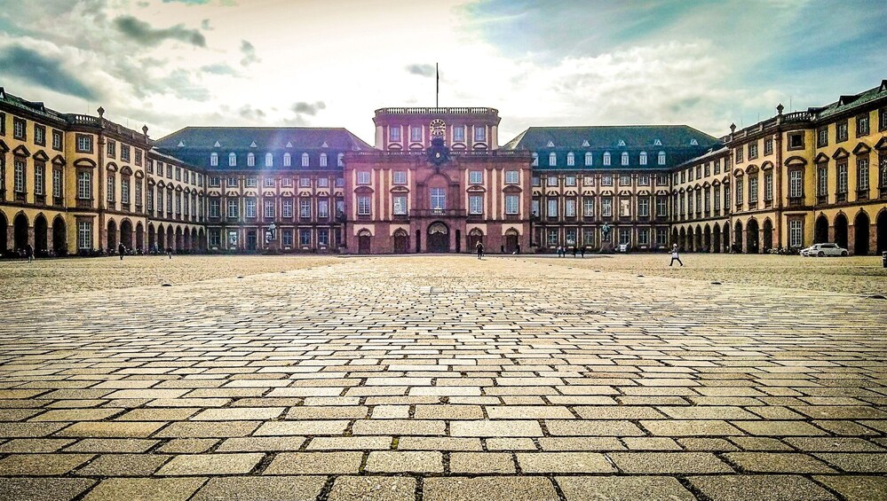 A large courtyard with a historic building in the background. 5