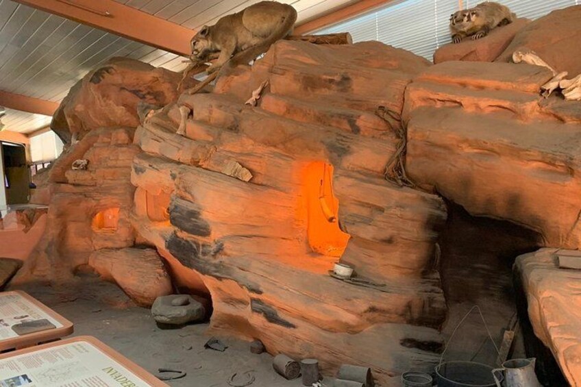 A large rock formation with a lion statue on top. 2