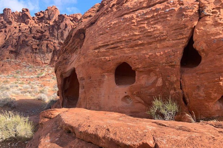 A red rock formation with multiple caves. 5