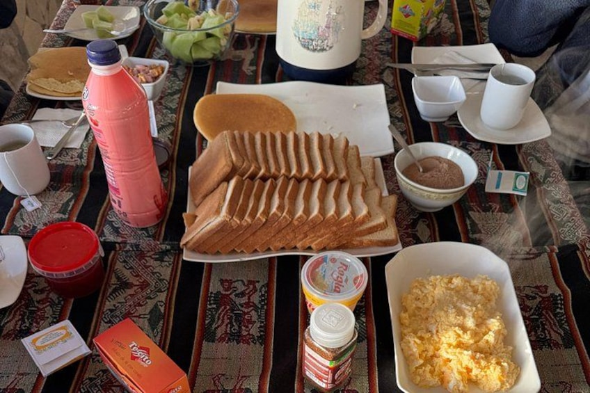 Ein Tisch mit Speisen, darunter Brot, eine Suppenschüssel, eine Saftflasche und ein Joghurtbecher. 5
