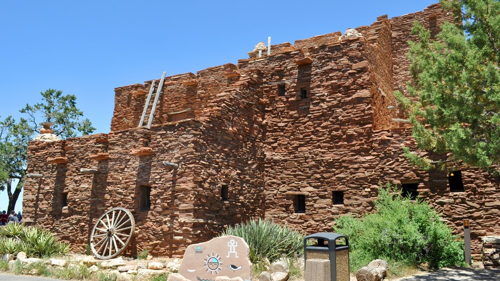 Un edificio histórico de piedra con una escalera y una rueda grande. 5