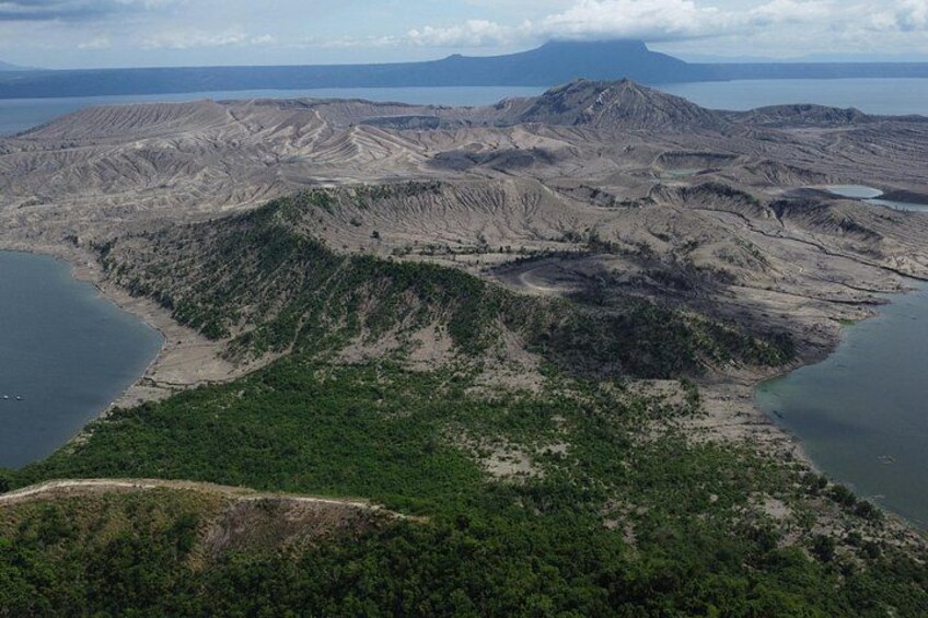 Un paysage accidenté avec une vaste étendue d’eau, une végétation luxuriante et des montagnes à l’horizon. 5