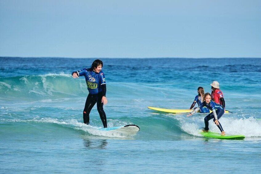 Family bonds on the waves! A father and child ride a party wave together, creating unforgettable memories.