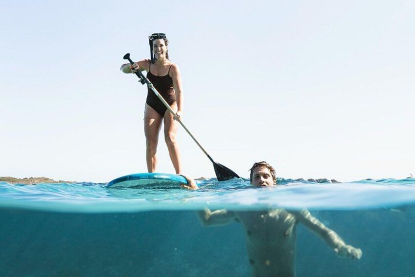 Dos personas haciendo paddleboard en un mar tranquilo con cielos despejados. 4