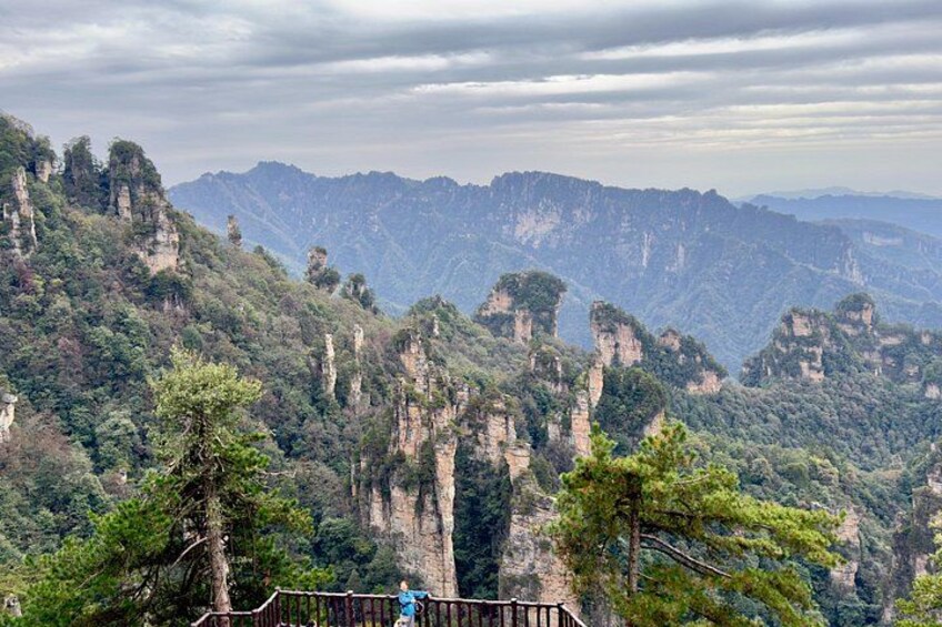 A mountainous landscape with prominent rock formations and dense forest. 2