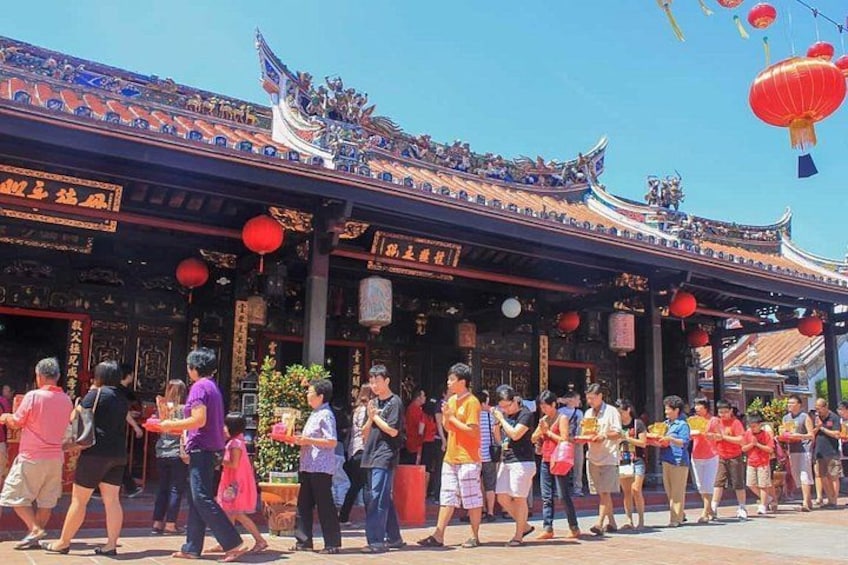 A traditional Chinese building with ornate architecture, red lanterns, and people gathered in front. 4