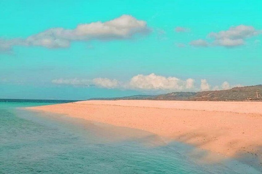 A beach with clear turquoise water, a sandy shore, and distant hills. 3