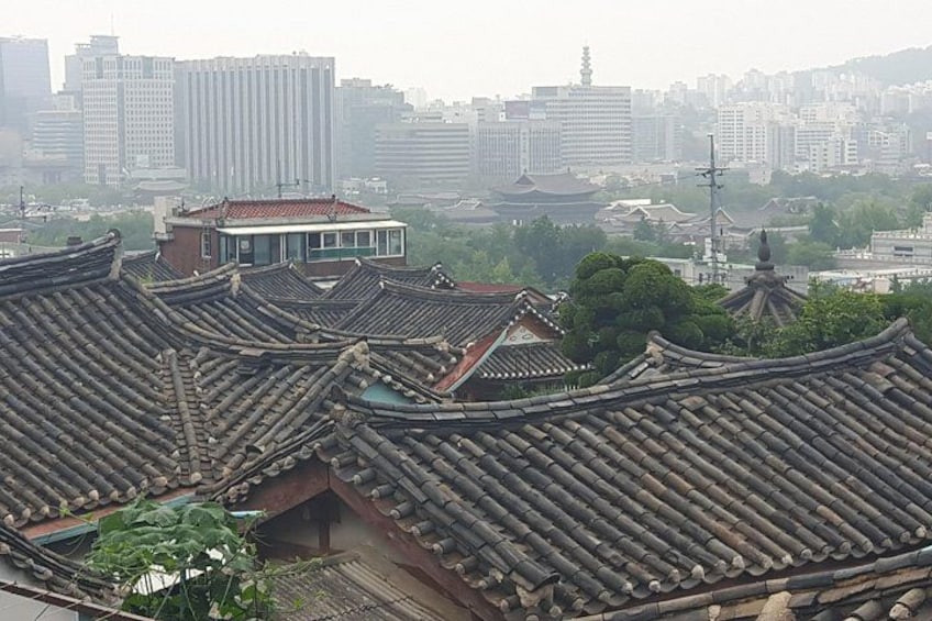 Traditional Korean rooftops with a modern building in the background. 2