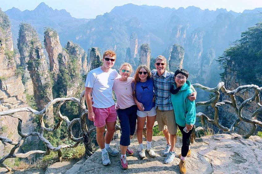 Un gruppo di persone in piedi su uno sperone roccioso, con un paesaggio montuoso sullo sfondo. 1