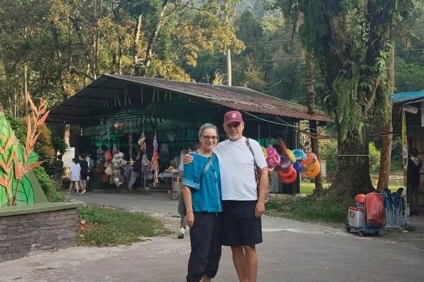 Dos personas frente a un mercado con productos de colores y una estructura cubierta. 3