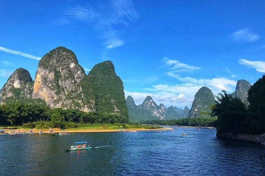 A river with boats, surrounded by limestone karst mountains. 3