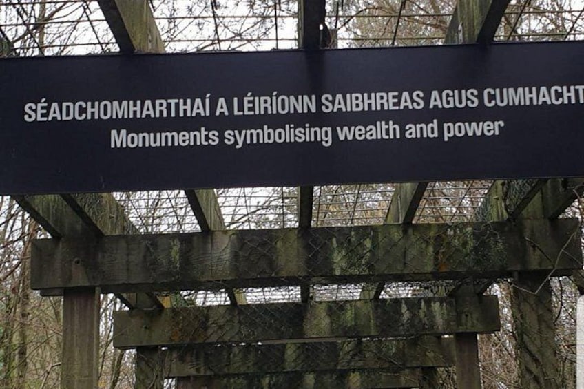 A sign with text in a foreign language, possibly Gaelic, mounted on a wooden structure. 3