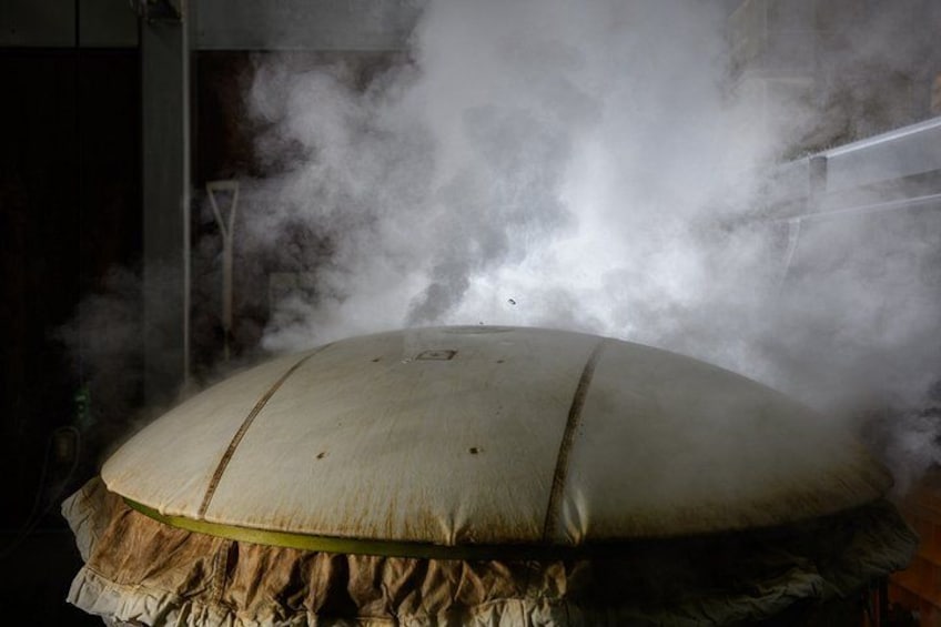 A large, round, white object emitting steam, surrounded by a ruffled fabric. 5